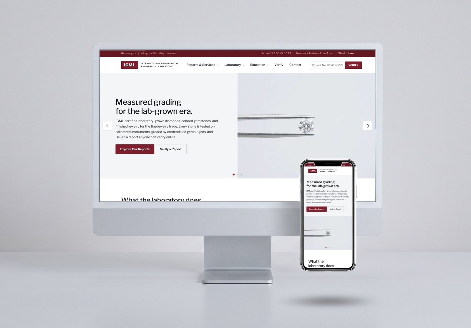 A desktop computer with a phone standing upright in front of it, both screens showing the IGML homepage