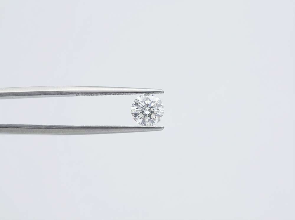 A diamond held in steel tweezers