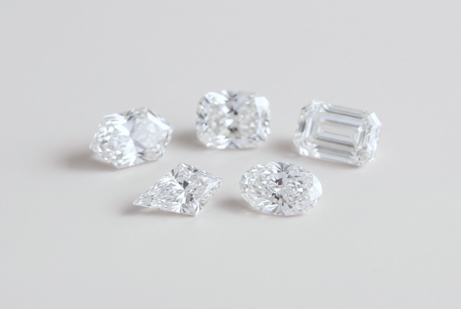 Five loose diamonds in unusual cuts, including an elongated hexagon, a cushion and a kite